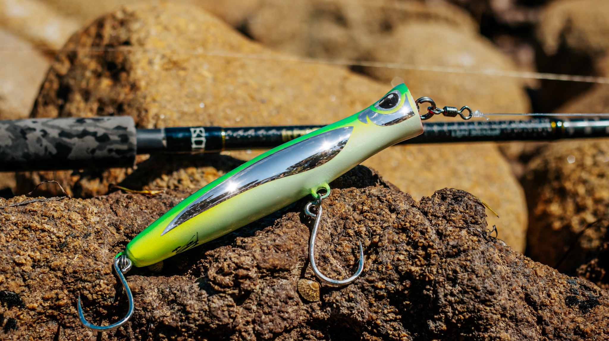 Green Viper Suave 150 resting on rocks beside a fishing rod